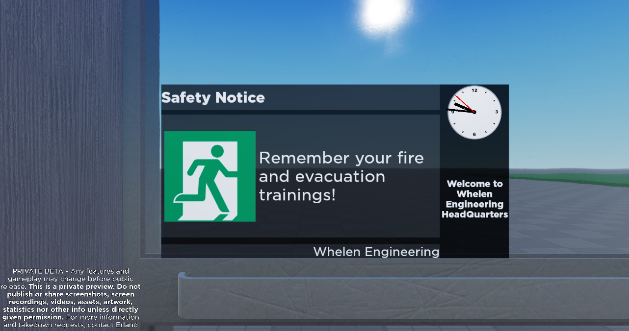 The same elevator. The camera is focused on a screen in the window which shows the current time and a reminder about evacuation trainings. The bottom left of the image has an copyright notice.